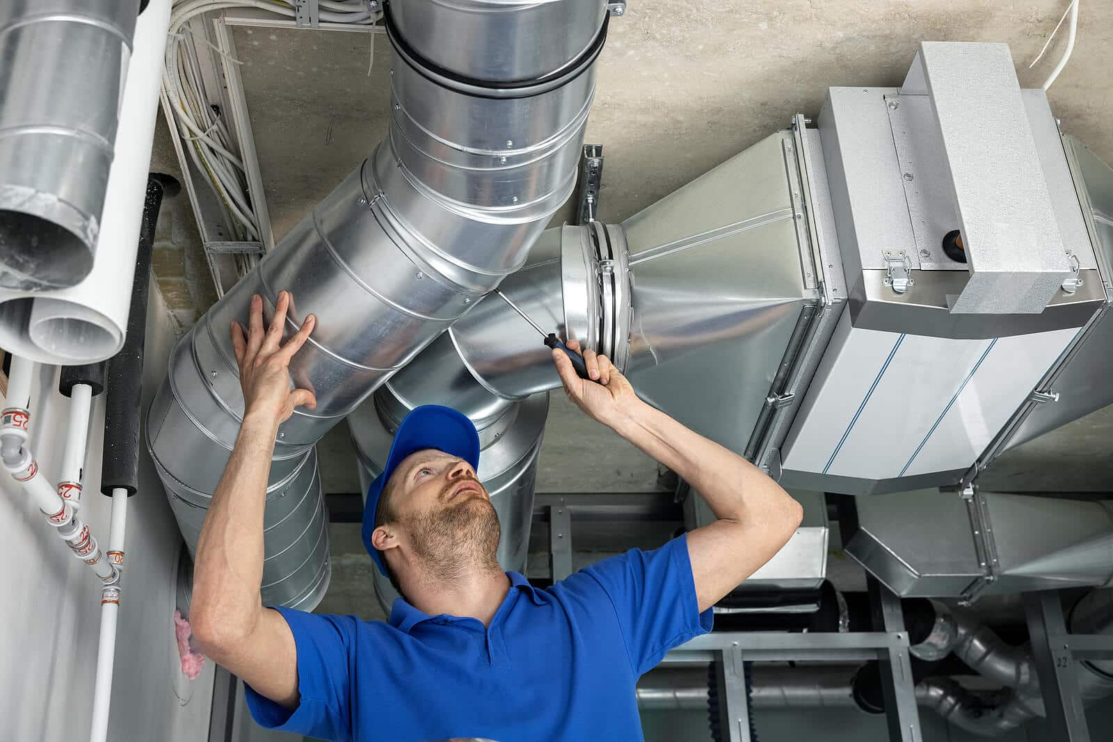 HVAC technician inspecting and repairing air ducts in Laguna Beach