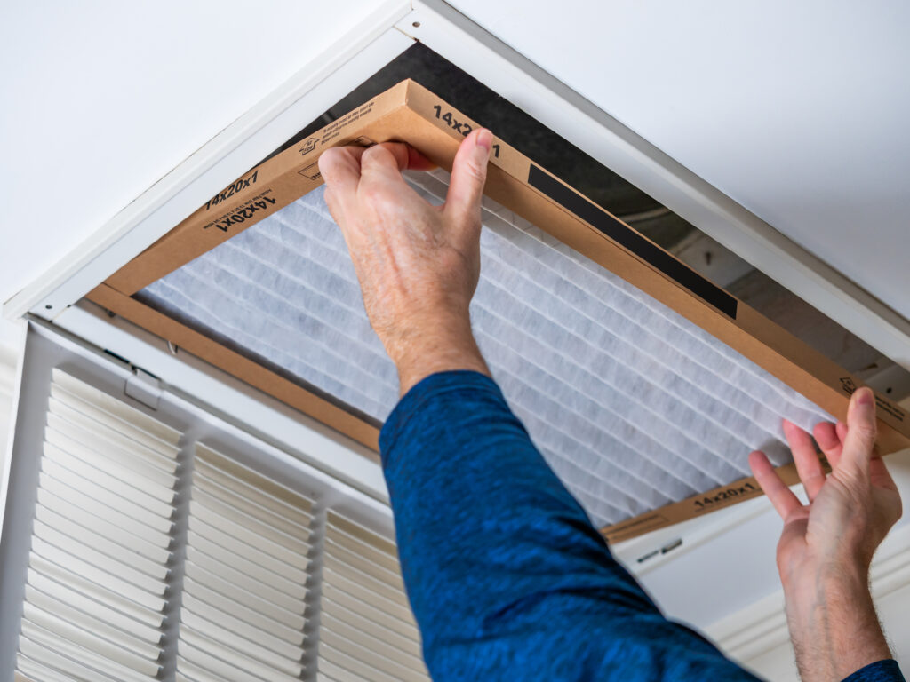 HVAC technician replacing a home air filter in Laguna Beach