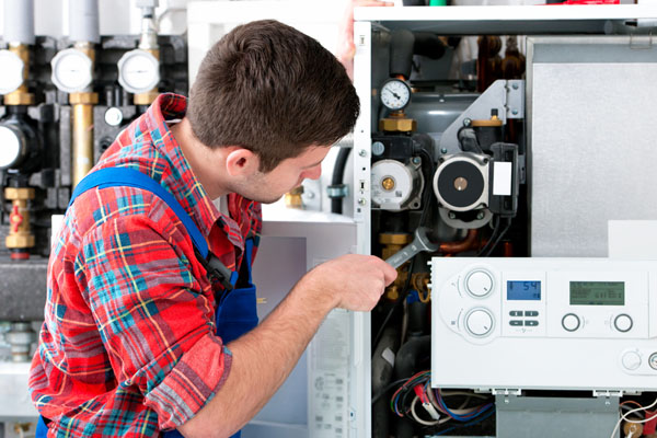 Heating technician repairing boiler controls in Laguna Beach