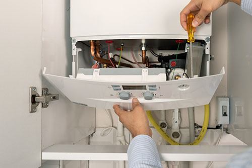 Heating technician repairing a residential boiler in Laguna Beach