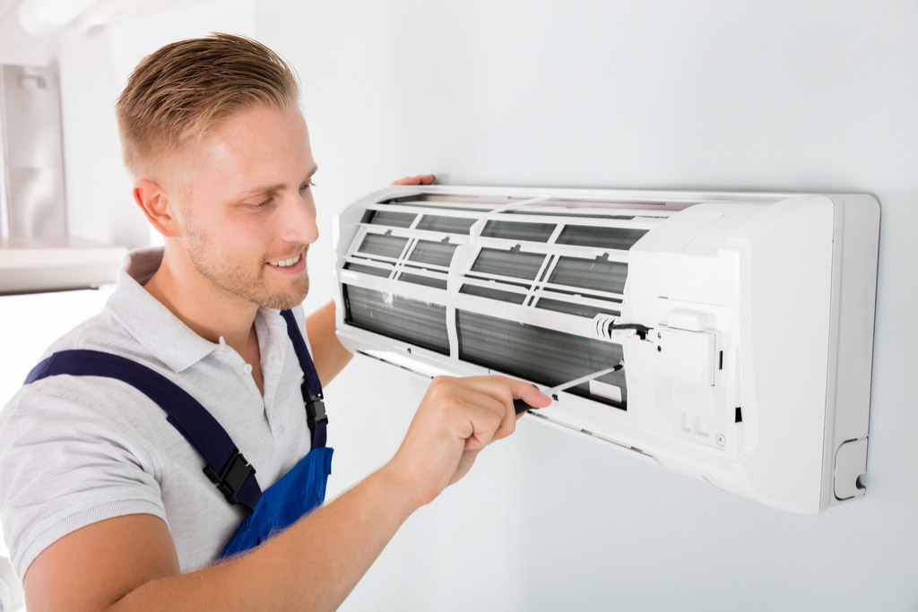 HVAC technician maintaining a ductless air conditioner in Laguna Beach