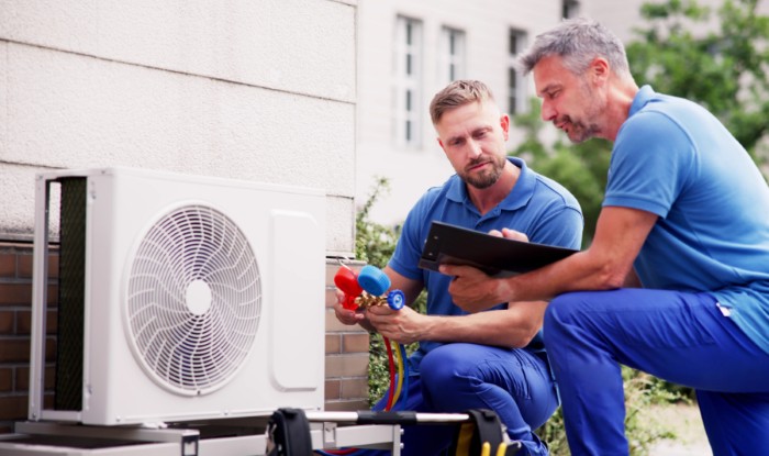HVAC technicians installing an outdoor air conditioning unit in Laguna Beach