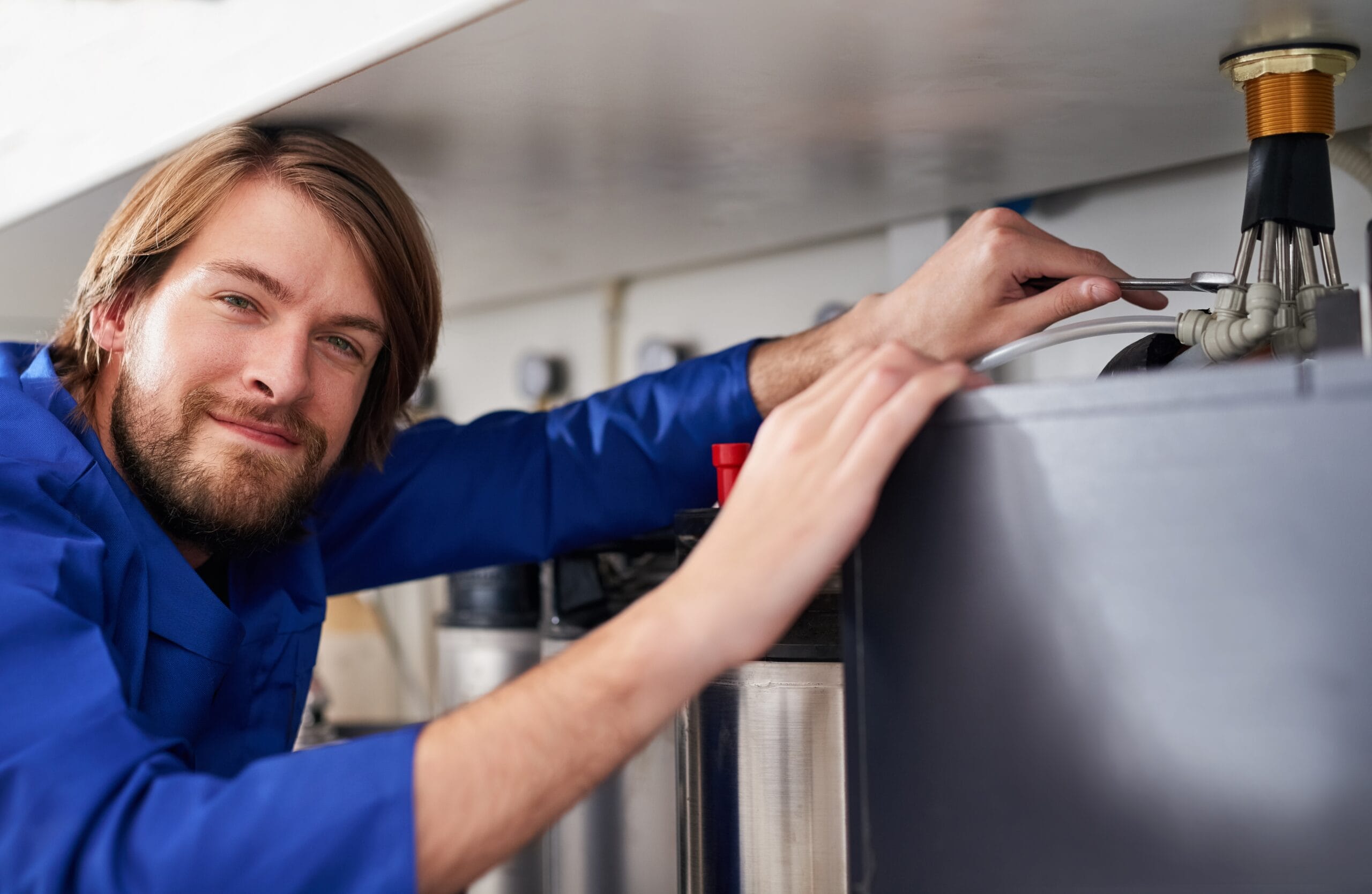 Technician servicing a residential water heater tank in Laguna Beach